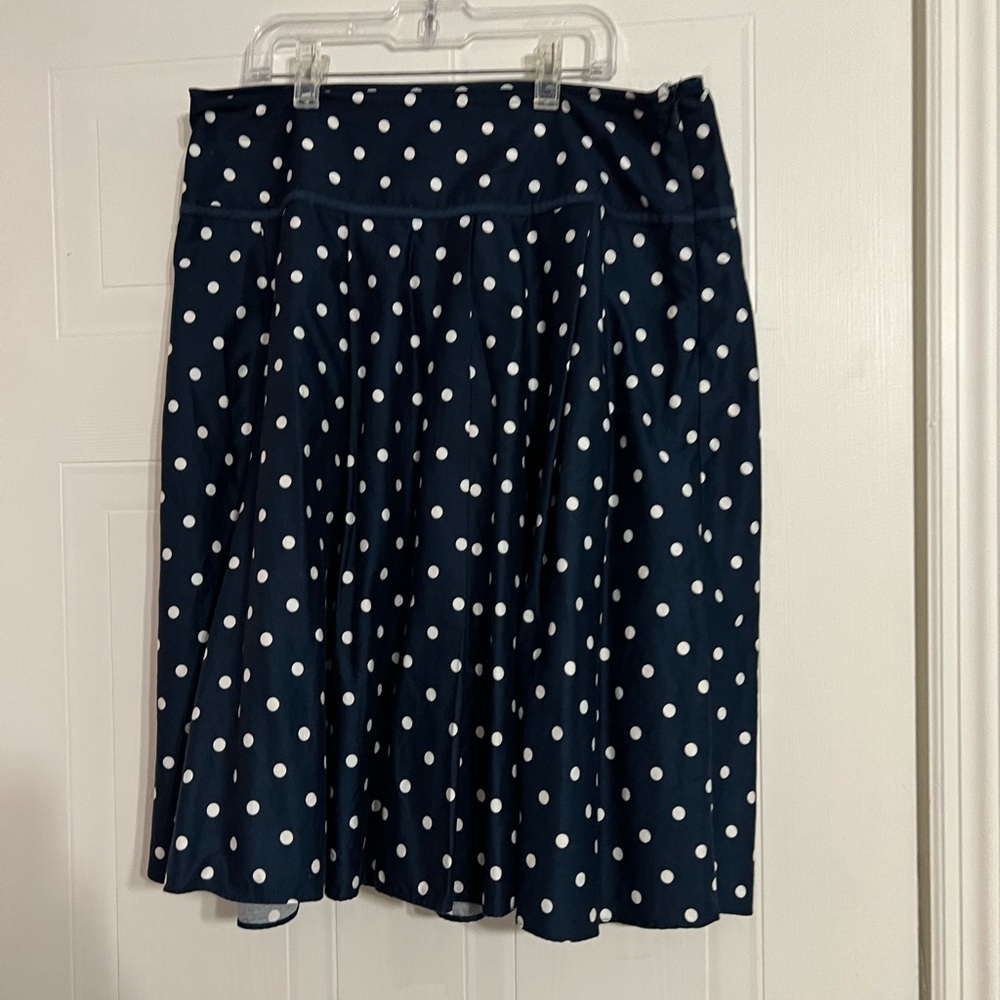 A cute, navy blue, polka dot patterned, knee length skirt